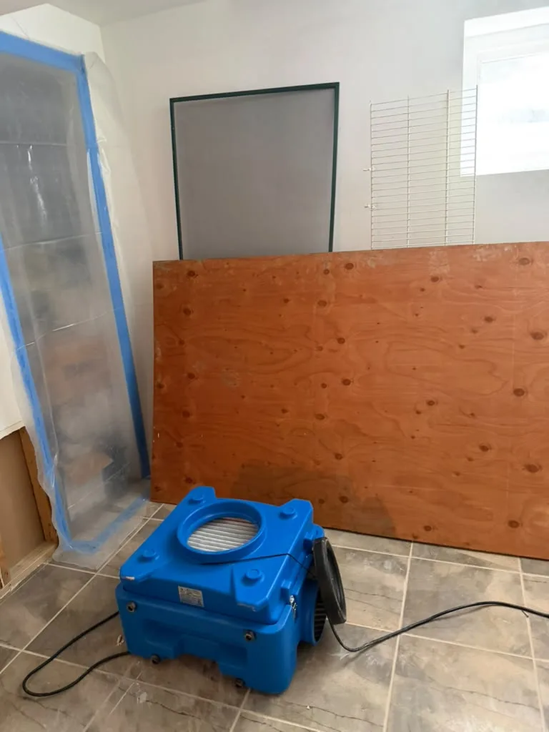 Poly containment wall with decontamination chamber and HEPA air scrubber in the basement