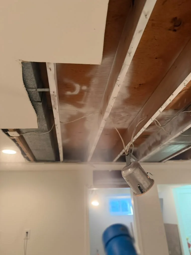 Exposed basement joists after cleaning with a HEPA air scrubber running